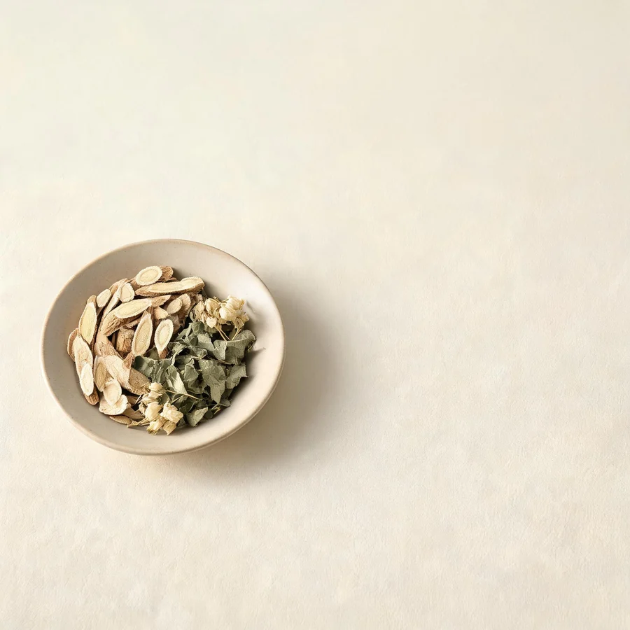 An editorial still life of the traditional Chinese herbs used for this condition, arranged on a warm off-white surface: pale cooling root.