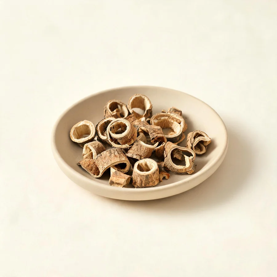 Dried Bai Xian Pi root bark arranged in a shallow bowl